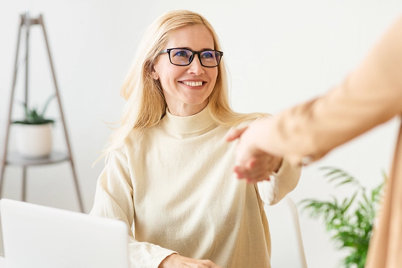 Woman smiling while shaking hands